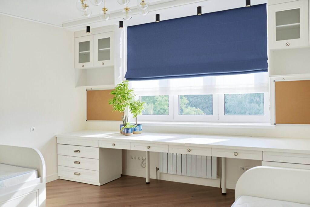 A cozy home room with a blue Roman blind, white furniture, and natural light.