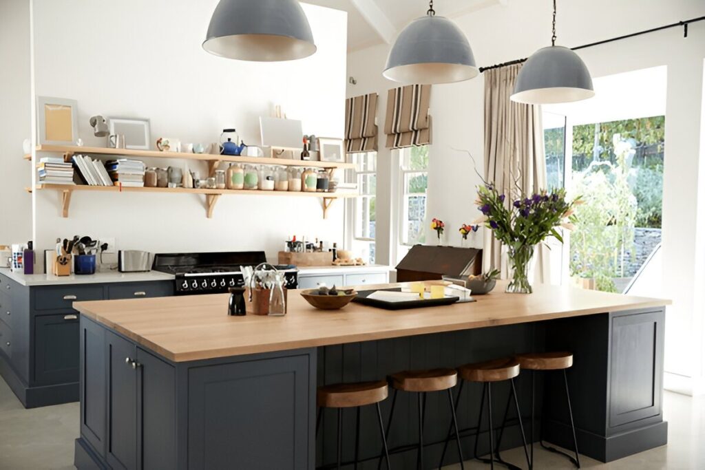 A modern kitchen and office snack bar featuring Roman blinds, wooden countertops, and pendant lighting.