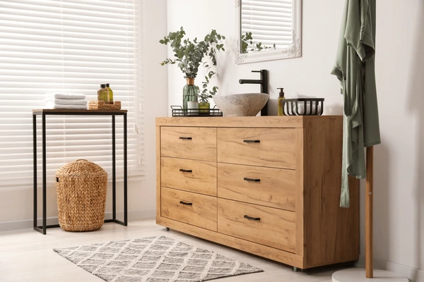 A modern bathroom with wooden vanity drawers, elegant décor, and sleek white window blinds, showcasing the best affordable and trendy window blinds in Dubai for 2025.