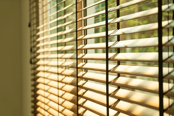 Close-up of eco-friendly bamboo window blinds filtering warm sunlight, creating a natural and sustainable ambiance in a modern Dubai home.