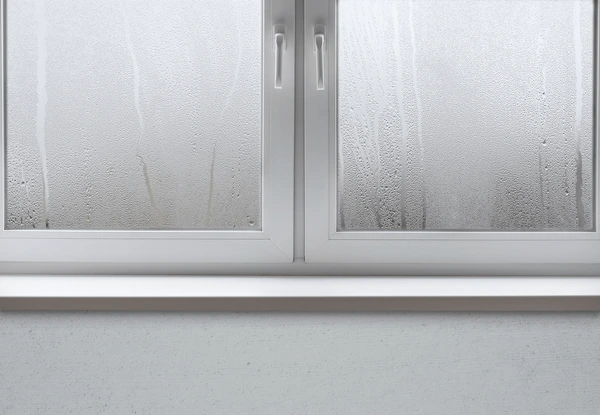 A modern double-glazed window covered in condensation, highlighting the need for moisture-resistant blinds in Dubai 2025 to reduce humidity and wet windows.