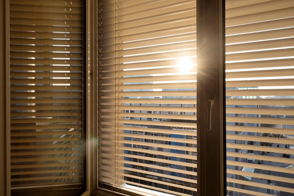 Sunlight filtering through modern window blinds in a Dubai high-rise, reducing glare and providing eye strain protection.