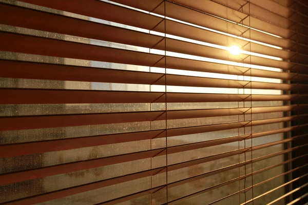 Sunlight streaming through elegant, light-filtering blinds, creating a warm and modern ambiance.