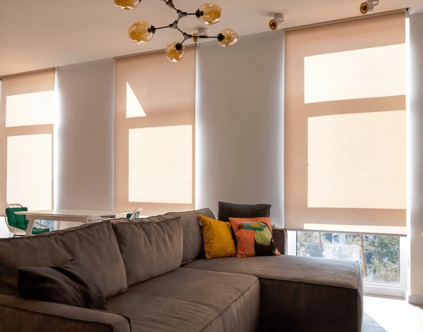 Stylish motorized roller blinds in a modern living room, offering privacy, heat reduction, and a contemporary aesthetic in a Dubai home.