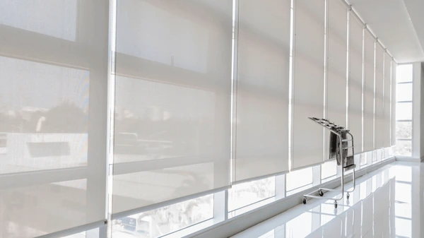 A modern office hallway in Dubai featuring sleek, floor-to-ceiling window blinds that provide glare reduction, privacy, and a professional aesthetic.