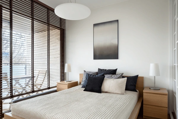 Modern bedroom with floor-to-ceiling windows featuring elegant wooden cut blinds in Dubai 2025, offering a sleek and contemporary design.