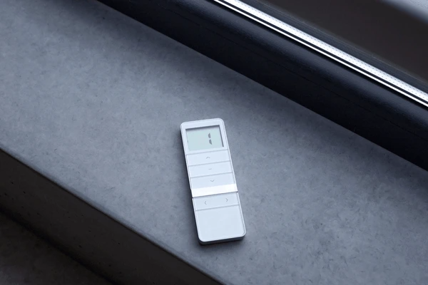 A sleek remote control for roman blind 2025 best and cheap in Dubai, placed on a modern windowsill, showcasing smart automation for effortless blind operation.