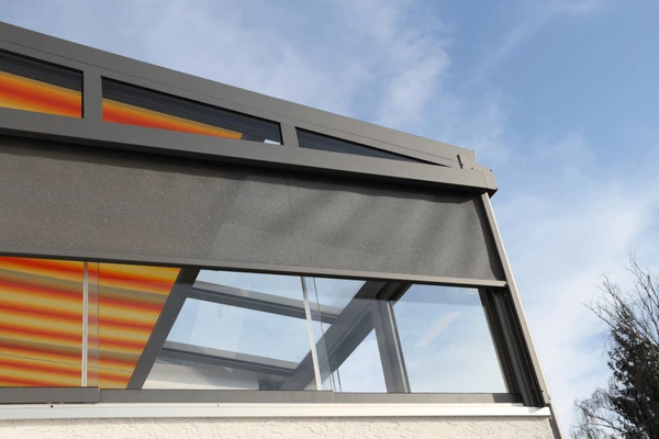 Exterior view of a conservatory with sleek roller blinds, showcasing the best blinds for conservatories in 2025—trendy, elegant, and built for sun protection.