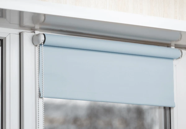 Stylish blue blackout roller blinds installed on a window, providing complete privacy and light control.