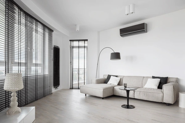 Stylish living room in Dubai with floor-to-ceiling long black blinds, modern furniture, and soft lighting