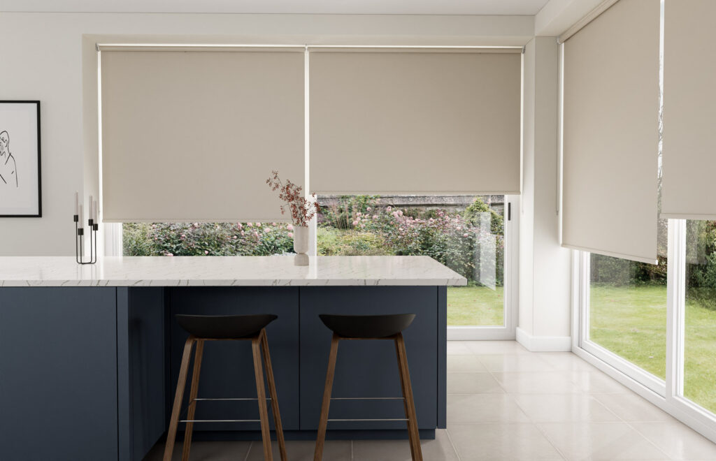Bright kitchen area with large patio doors covered by elegant cream-colored roller blinds.