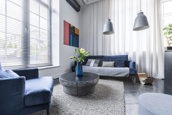 Contemporary Dubai living room with soundproof blinds, blue furniture, and cozy modern interior