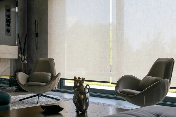 Stylish living room with floor-to-ceiling motorized roller blinds, modern lounge chairs, and a refined interior setup in Dubai, 2025.