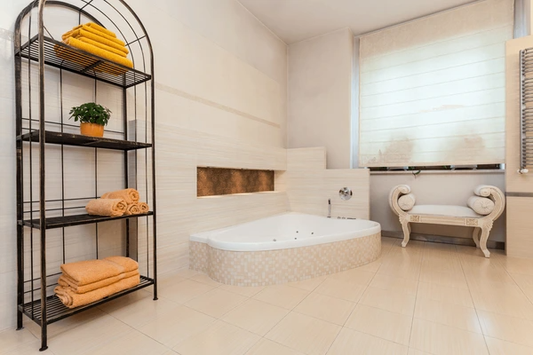 A sophisticated bathroom with a built-in bathtub, soft Roman blinds, and stylish décor, creating a cozy and elegant ambiance.