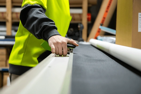 Professional cutting fabric for modern roller blinds, showcasing expert craftsmanship in Dubai 2025.