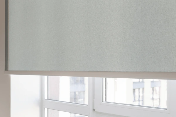 Best Long Blinds in Dubai 2025 - Close-up of light gray roller blinds covering a large window, blending luxury with modern design.