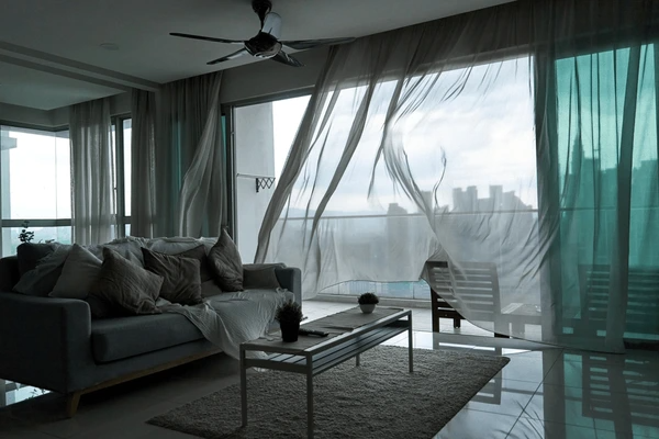 Modern living room with custom-made soundproof blackout curtains, creating a sleek and cozy atmosphere.