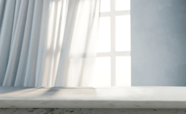 Best Drop Curtains in Dubai 2025 - Soft, airy curtains gently flowing by a bright window, adding elegance to a modern home with a marble desk.
