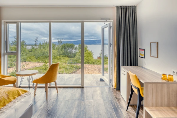Best Drop Curtains in Dubai 2025 - Elegant dark curtains complementing a modern bedroom with a view of nature and a minimalist design.