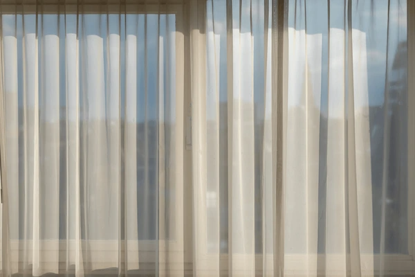 Energy-efficient sheer curtains allowing soft light into a bright room, perfect for modern Dubai homes in 2025