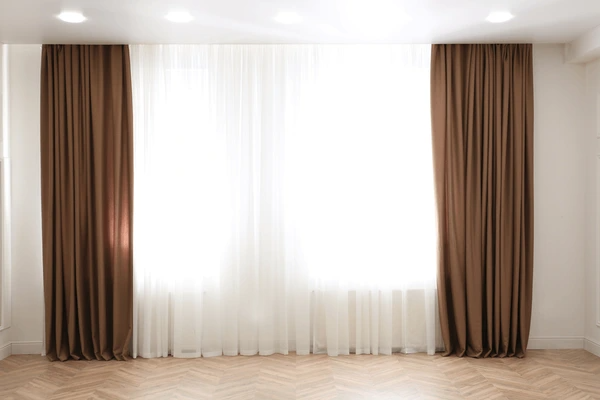 Sleek bedroom with floor-to-ceiling curtains, blending modern design with superior heat control.