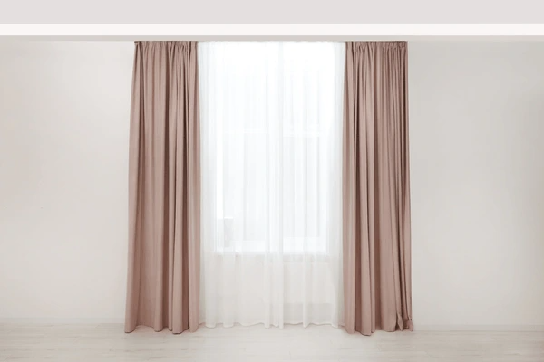 A minimalist interior with beige and white shrink-proof curtains that add an elegant and sophisticated touch to the room’s décor.
