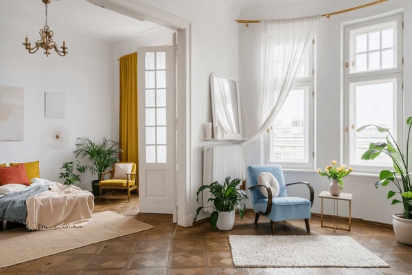 A modern living space with vibrant yellow and white shrink-proof curtains, adding elegance and light to a stylish, cozy apartment with natural plants.