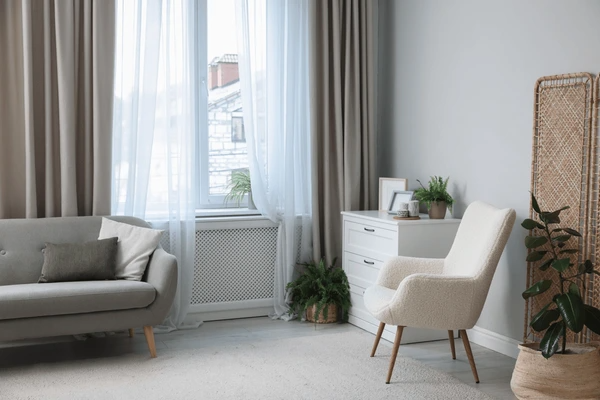 Modern living room in Dubai with sleek, unwrinkled beige curtains, soft sheer layers, and cozy neutral furniture creating an elegant, luxurious ambiance.