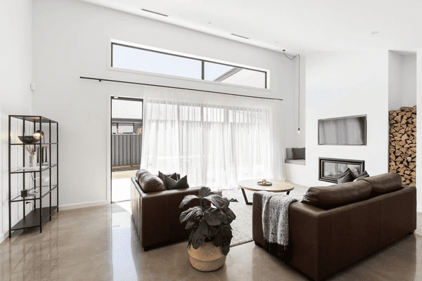 A bright Dubai living room with sheer white curtains over large sliding glass doors, creating a cozy, modern, and elegant open-plan interior.