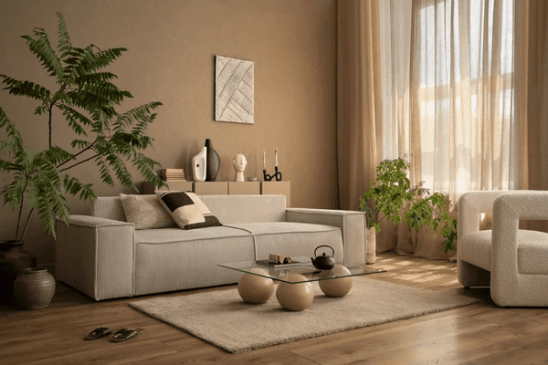 Elegant beige living room with soft, floor-length sheer curtains allowing filtered sunlight to enhance a cozy, modern aesthetic.

