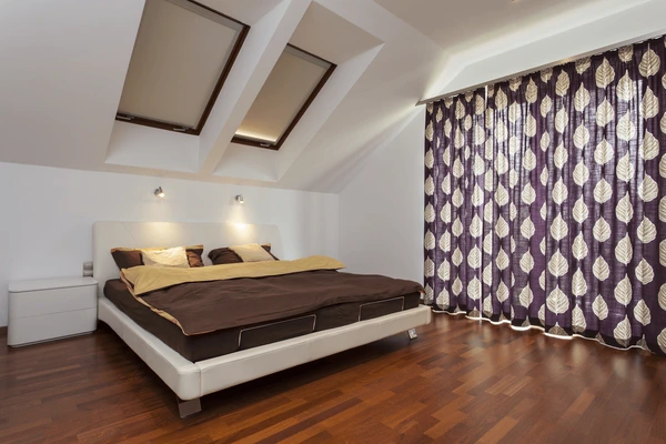 Stylish bedroom with bold patterned curtains featuring leaf designs, adding elegance and warmth to a sunlit modern Dubai home.