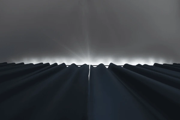 Best Blackout Curtains on Grey Wall in Dubai 2025, showing stylish dark blackout drapes fully drawn against a soft grey wall with light subtly peeking from behind.