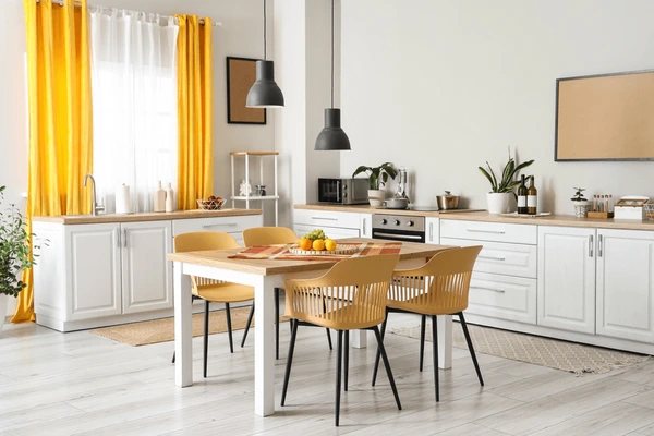 Best Measured Curtains in Dubai 2025, featuring yellow sunshine drapes in a white modern kitchen with a wooden dining table and minimalist decor for cozy, trendy homes.