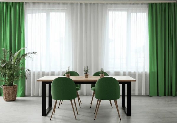 Modern dining room with elegant green and white stylish curtains, wooden table, and green chairs in a cozy Dubai home 2025.