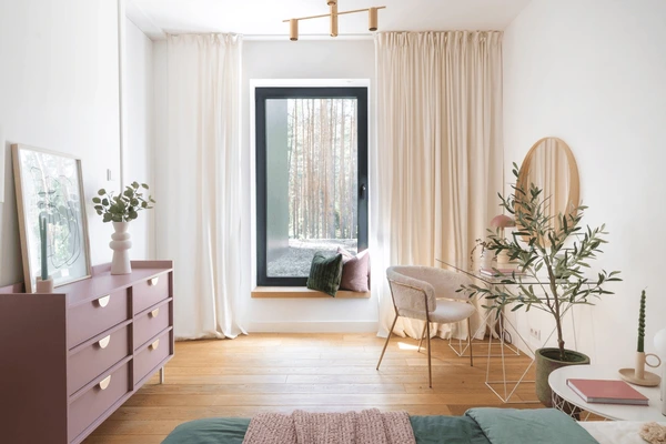 Bright modern bedroom with soft cream washable curtains, wooden floors, and pastel furniture creating a cozy, elegant space.