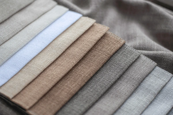 A collection of soft beige, gray, and taupe fabric samples from Emirati Blinds & Curtains in Dubai 2025, showcasing premium materials ideal for luxurious and modern Halloween curtains.