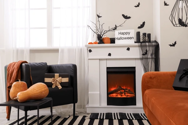 Stylish Halloween-themed living room in Dubai with white sheer curtains, pumpkins, and festive fireplace decorations.